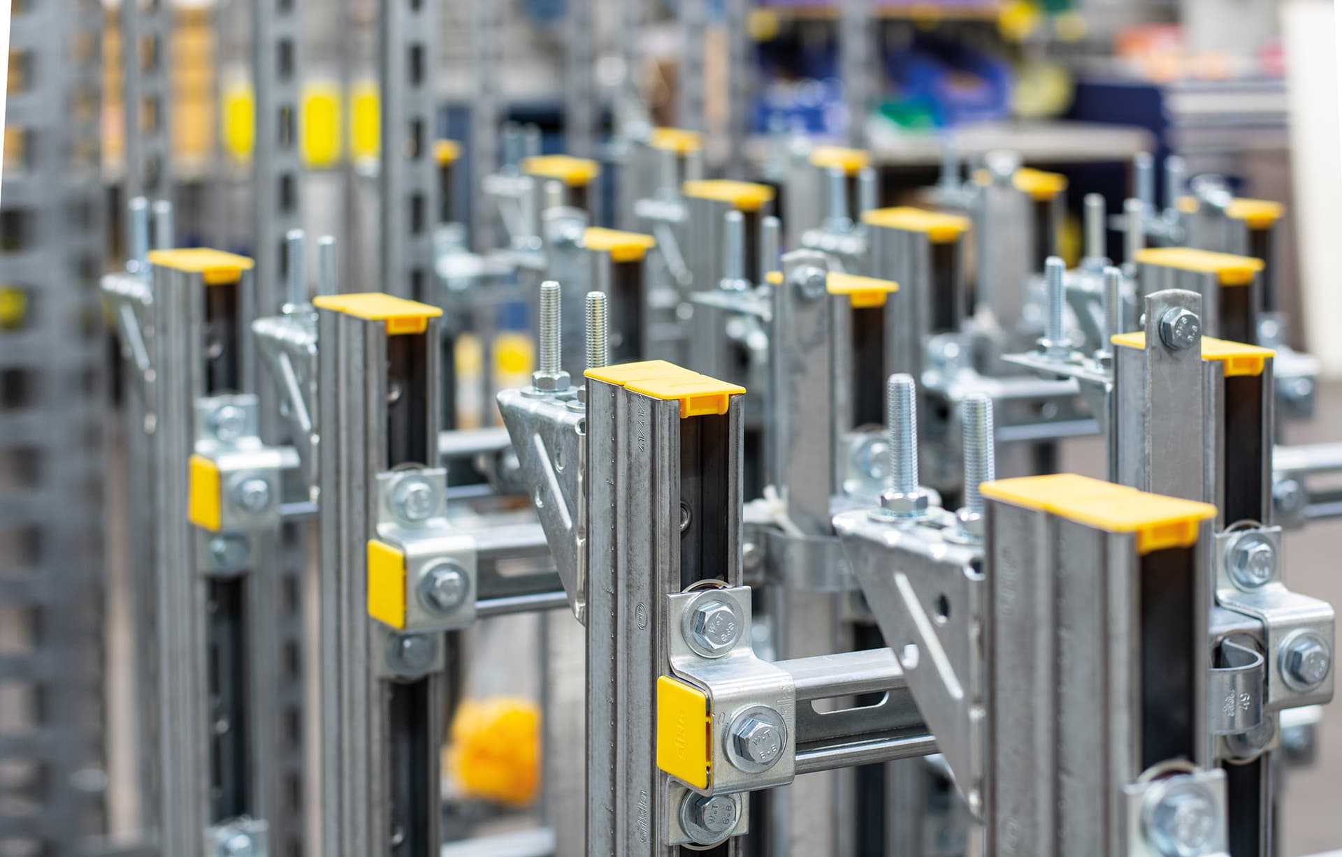 Close-up of metal shelving brackets with yellow caps in a hardware store, arranged in rows and ready for assembly.