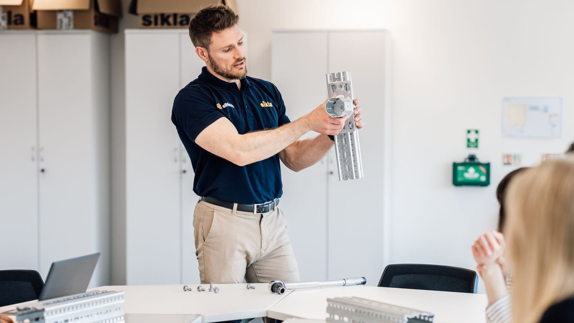 Person staning in front of people, having Sikla products in hand.